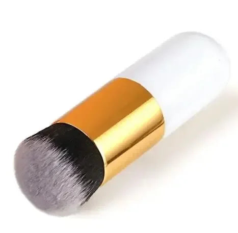 Makeup brush with gold handle and black bristle head on a white background