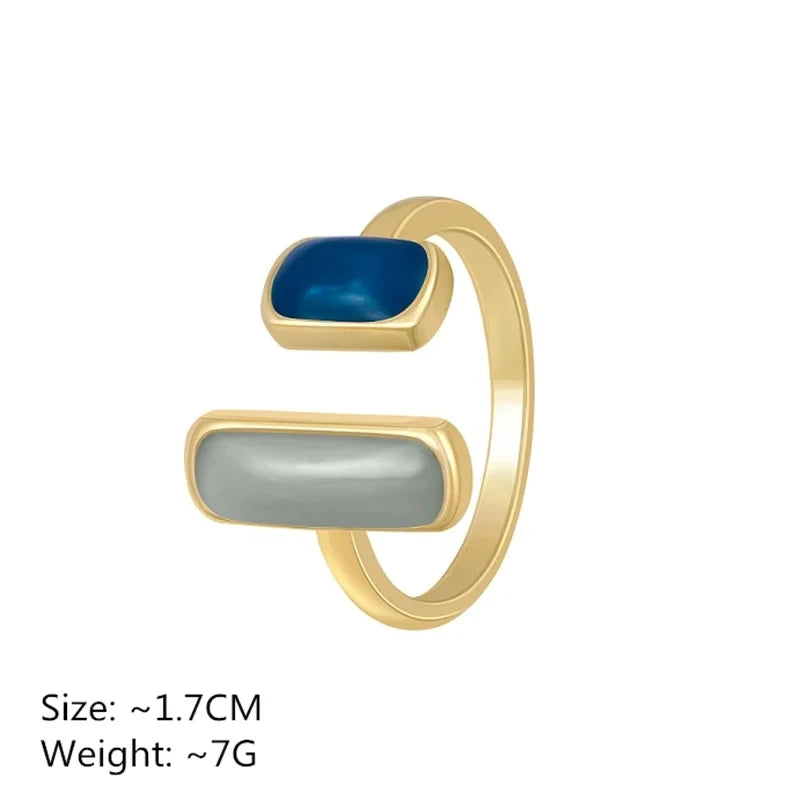 Gold ring with blue and gray stones on a white background