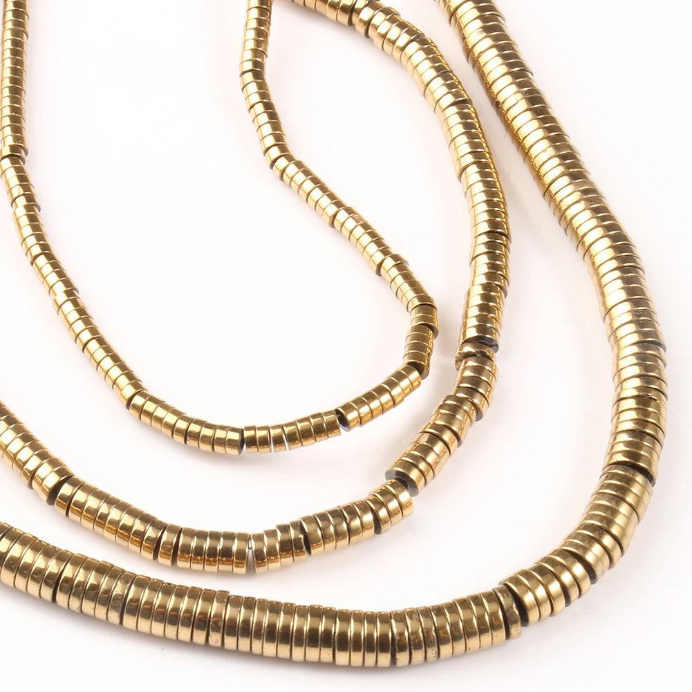 Three gold necklaces with a heishi bead design on a white background