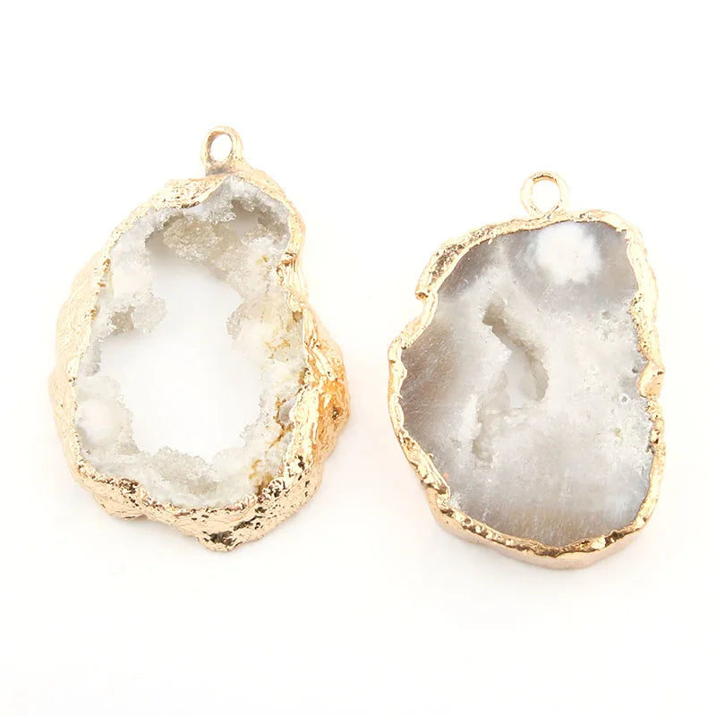 Two gold-rimmed stone pendants on a white background