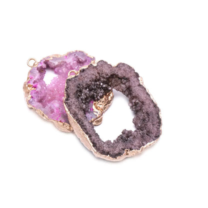 Two geode slices with pink and purple interior on a white background