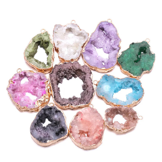 Assorted colorful geode-like pendants with gold edges on a white background
