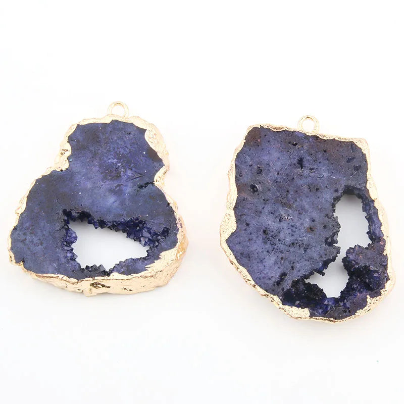 Pair of purple geode-style earrings with gold accents on a white background
