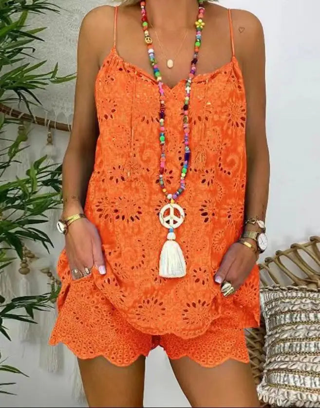 Person wearing an orange lace romper with a colorful necklace against a white background