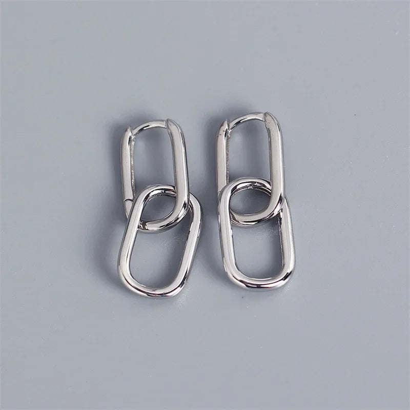 Pair of silver hoop earrings on a gray background