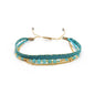 Turquoise and gold bracelet with beads on a white background