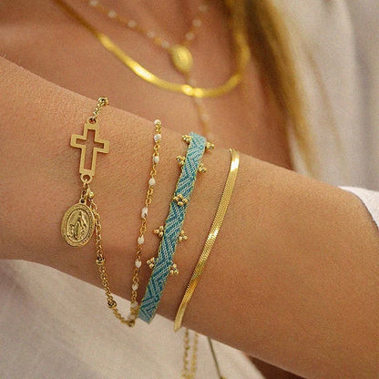 Close-up of a wrist wearing multiple gold and turquoise bracelets.
