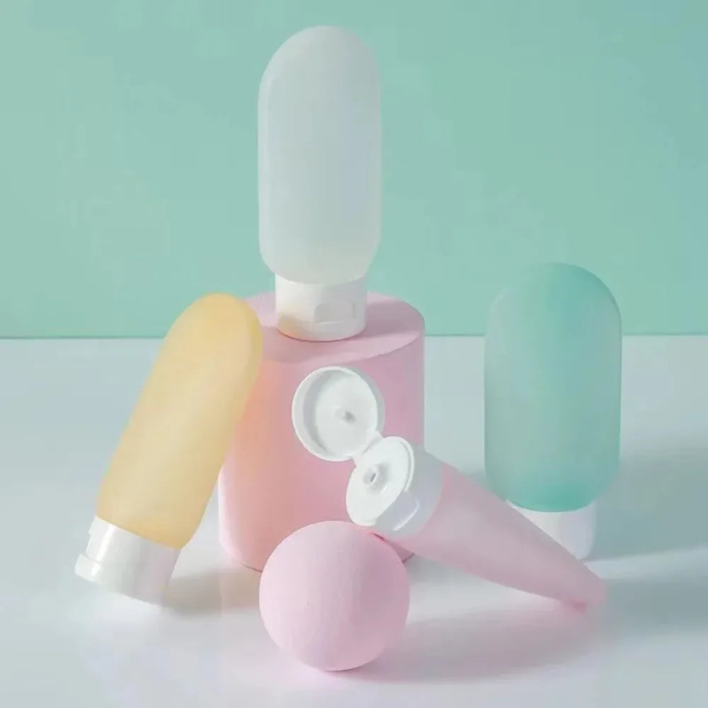 Set of pastel-colored cosmetic bottles on a light green background