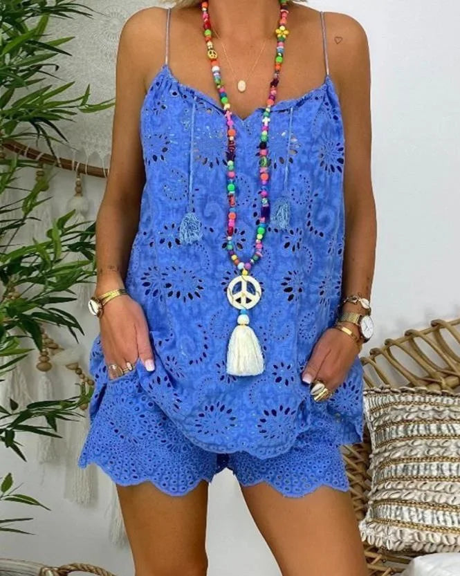 Person wearing a blue lace dress with a colorful necklace against a white wall.