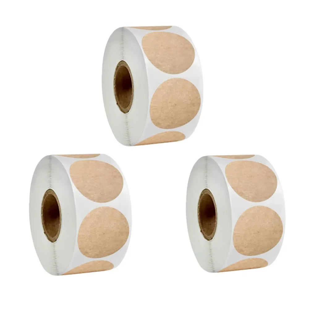 Three rolls of round beige stickers on white background