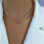 Pink beaded necklace with a heart pendant on a mannequin