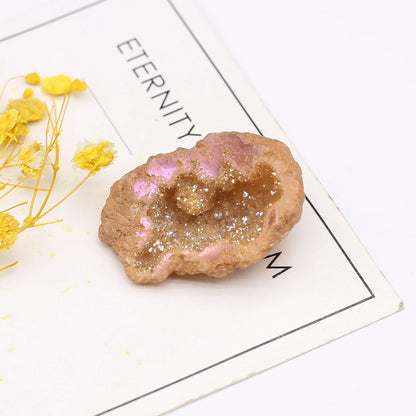 Decorative rock with pink interior on a white surface with yellow flowers and text.