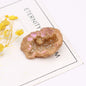 Decorative rock with pink interior on a white surface with yellow flowers and text.