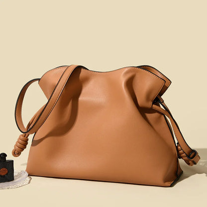 Brown leather handbag on a beige background