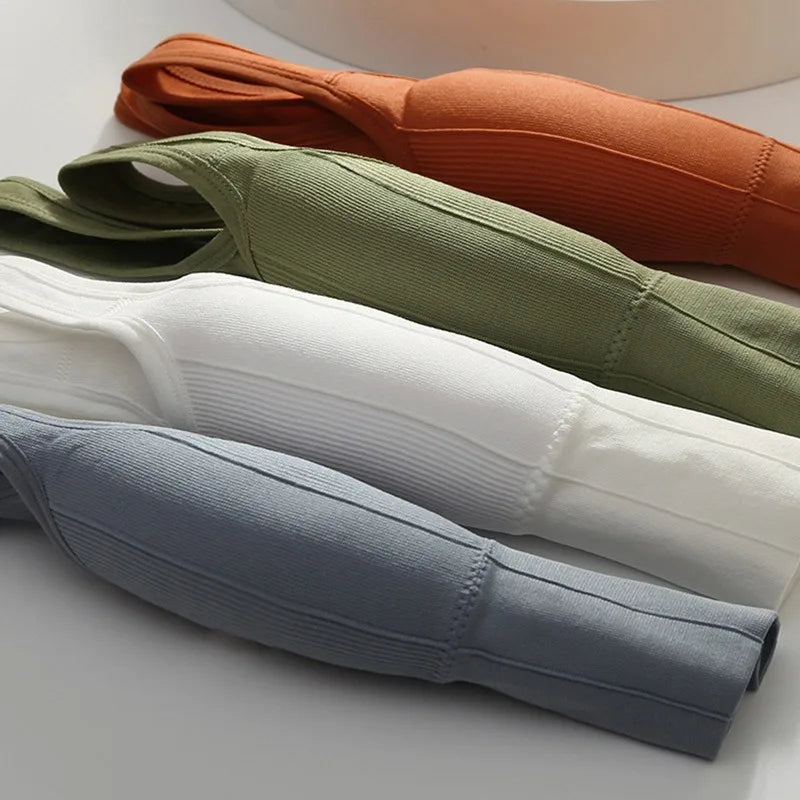 Four folded fabric strips in green, orange, white, and blue on a light background