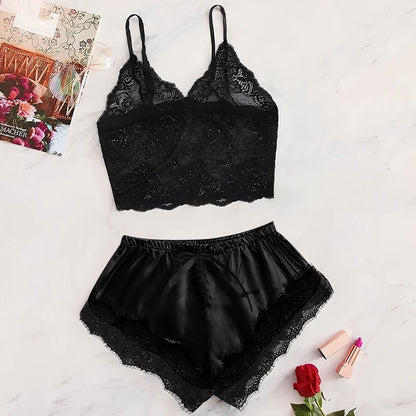 Black lace lingerie set on a light surface with a magazine and rose in the background