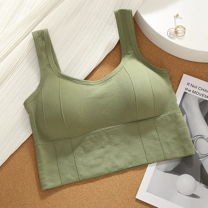 Green ribbed tank top on a cork surface with a magazine underneath