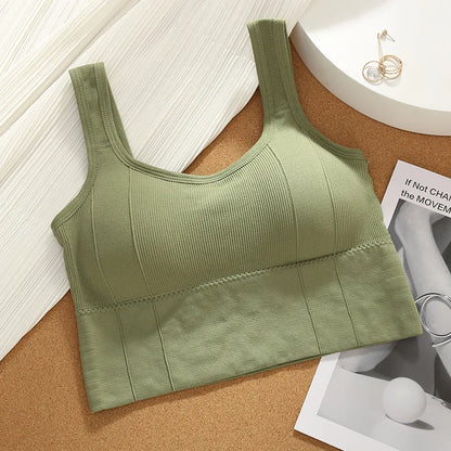 Green ribbed tank top on a cork surface with a magazine underneath
