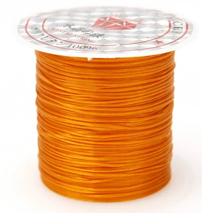 Spool of orange thread on a white background