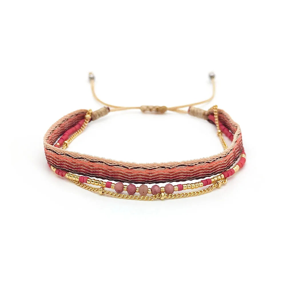 Multistrand bracelet with red and gold accents on a white background
