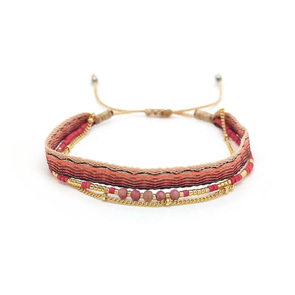 Multistrand bracelet with red and gold accents on a white background