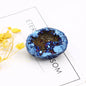 Blue geode crystal on a white surface with yellow flowers