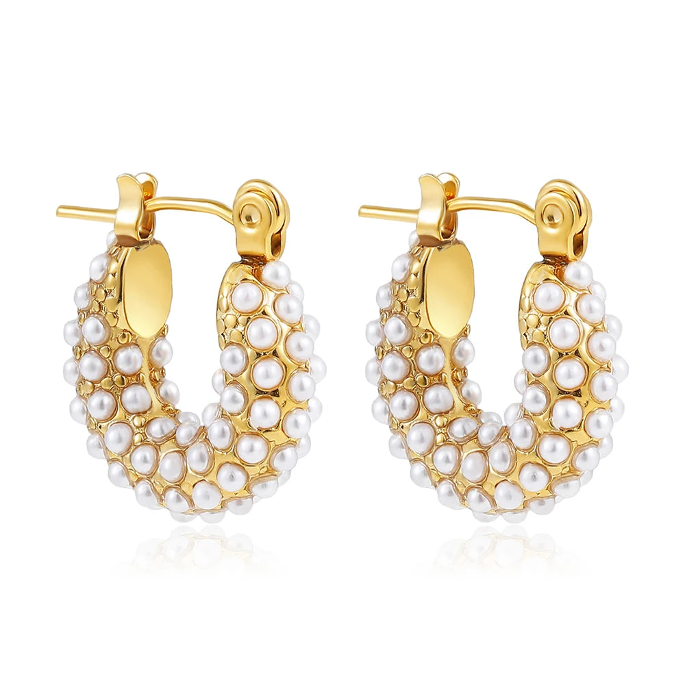 Gold hoop earrings with pearl detailing on a white background