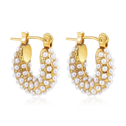 Gold hoop earrings with pearl detailing on a white background