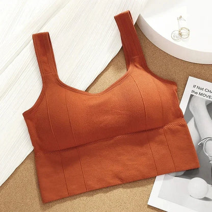 Orange crop top on a textured surface with a magazine in the background