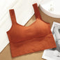 Orange crop top on a textured surface with a magazine in the background