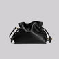 Black leather drawstring bag on a light gray background