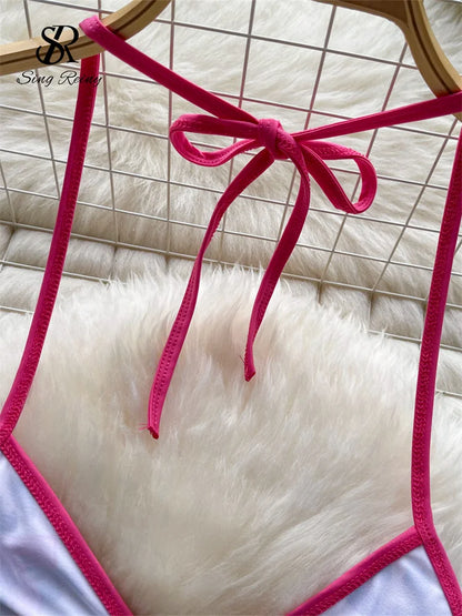 White bikini bottom with pink straps on a white fur surface