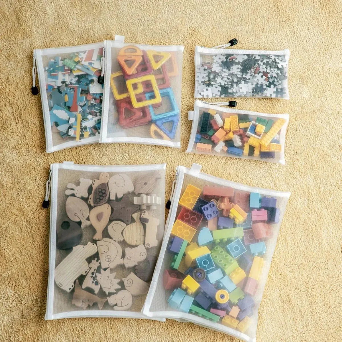 Collection of colorful wooden puzzle pieces in transparent bags on a beige surface