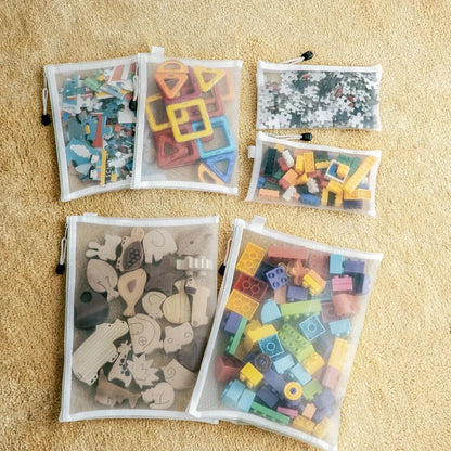 Collection of colorful wooden puzzle pieces in transparent bags on a beige surface