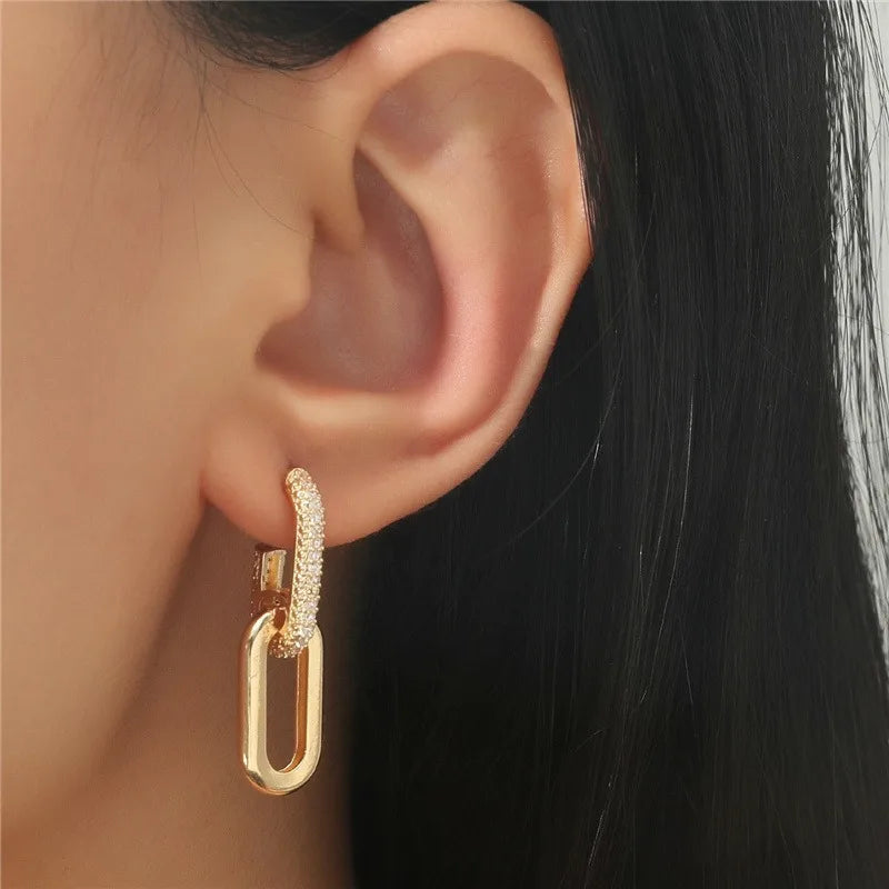 Gold hoop earring with clear stones worn by a person