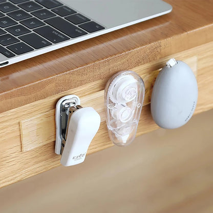 Three small electronic devices attached to a wooden surface next to a laptop.