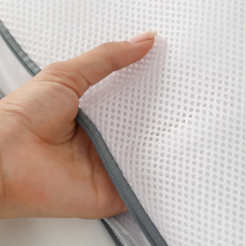Hand holding a textured white fabric with gray trim