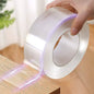 Roll of clear tape being applied to a wooden surface with a blurred background