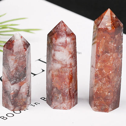 Three crystal towers with red and white patterns on a white surface.