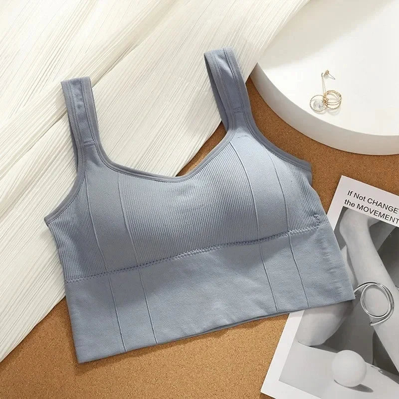 Light blue ribbed tank top on a textured surface with a magazine underneath