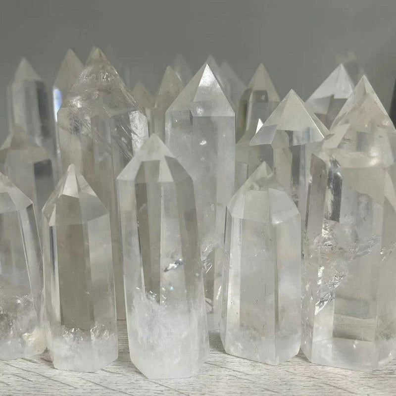 Collection of crystal quartz points on a wooden surface with a neutral background