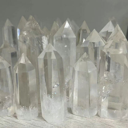 Collection of crystal quartz points on a wooden surface with a neutral background