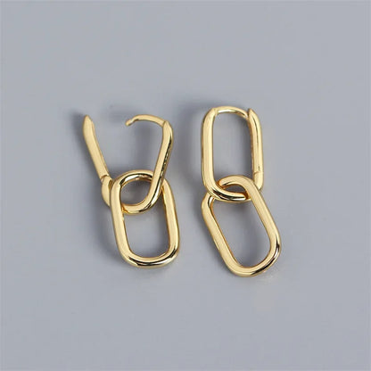 Pair of gold hoop earrings on a gray background