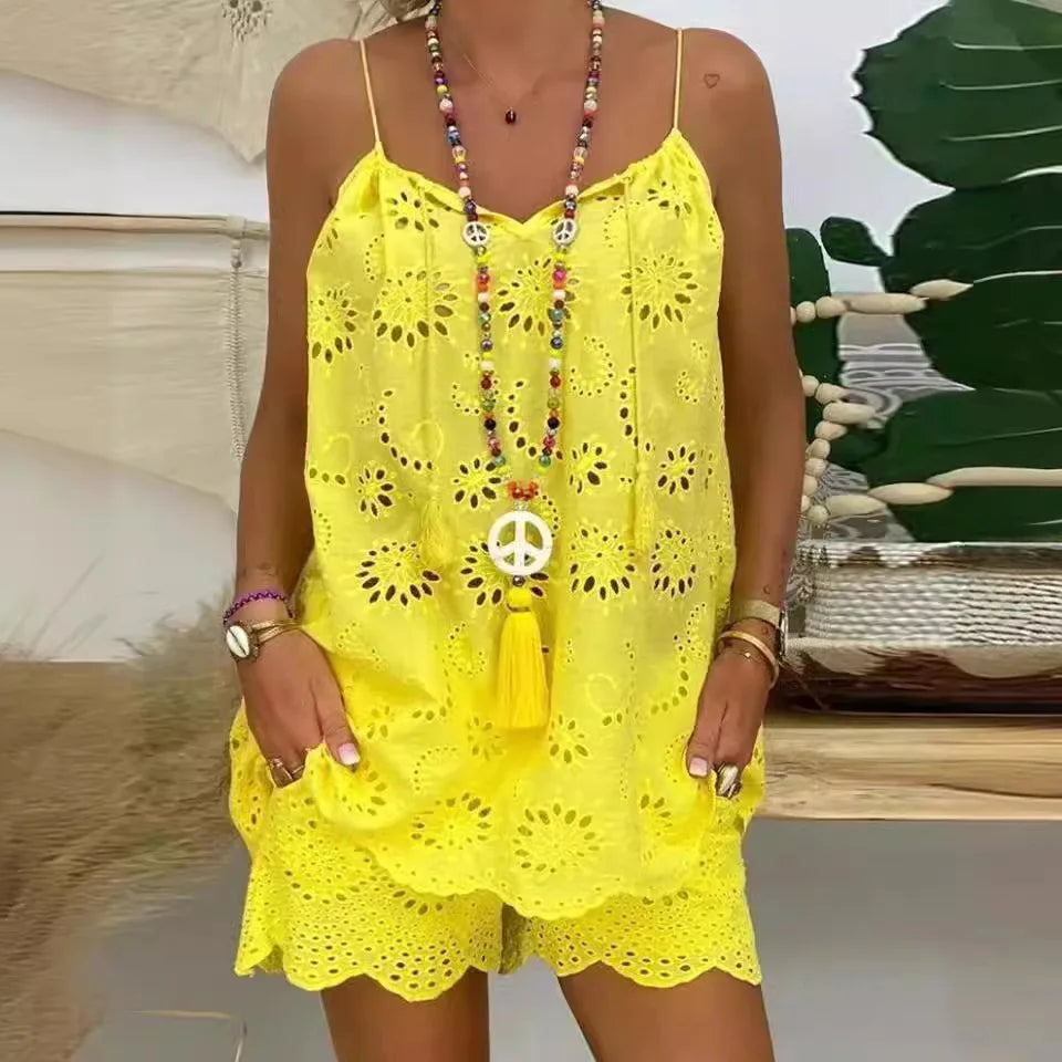 Person wearing a yellow lace dress with a decorative necklace against a blurred outdoor background
