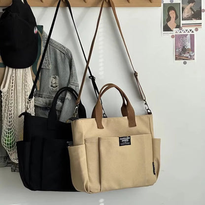 Two bags, one black and one beige, hanging on a wall with a white background.