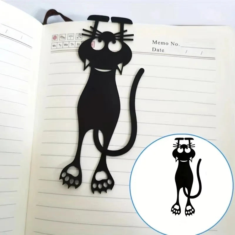 Black cat-shaped bookmark on a notebook page with an inset showing a close-up of the cat design.
