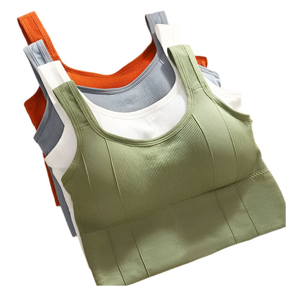 Stack of green, orange, gray, and white tank tops on a cork board background.