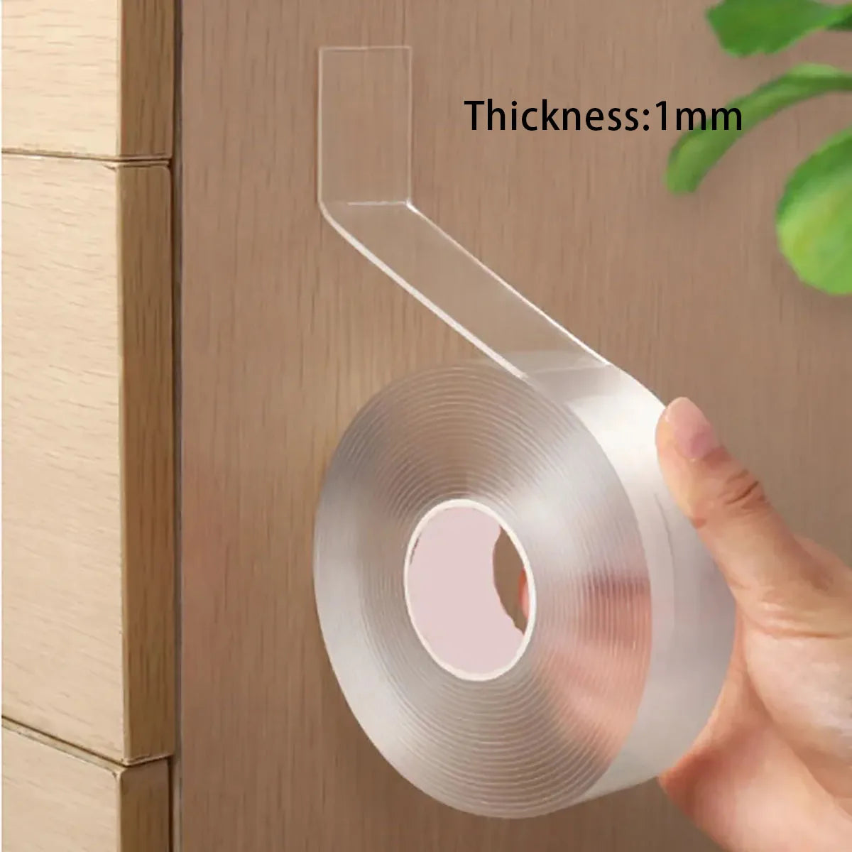 Clear adhesive tape with a thickness of 1mm being applied to a wooden surface.