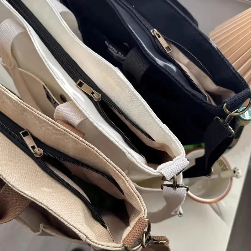 Close-up of multiple bags with zippers and straps on a neutral background
