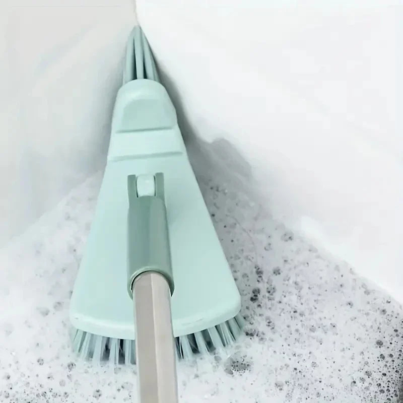 Green cleaning brush with a handle being used to scrub a toilet bowl.